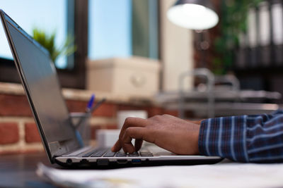 Cropped hands using laptop at office