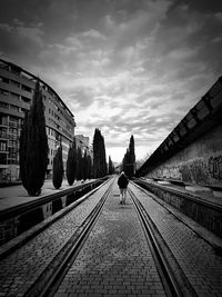 Railroad tracks against cloudy sky