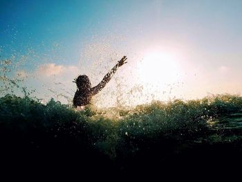 Person swimming in sea against sky