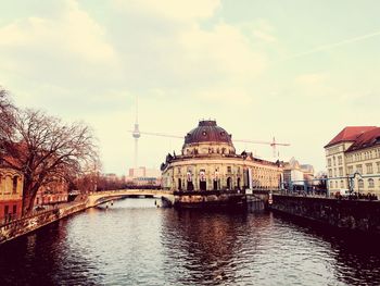 Bridge over river amidst buildings in city