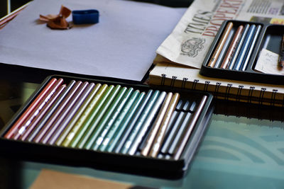 High angle view of colored pencils on a glass table