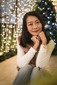 Portrait of young woman sitting on sofa at home