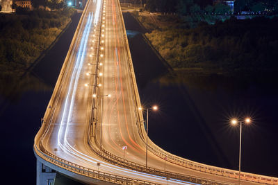 Highway at night lights. fast car light path, trails, streaks on interchange bridge road. night