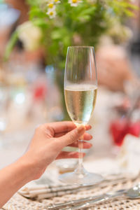 Cropped hand of woman holding champagne flute
