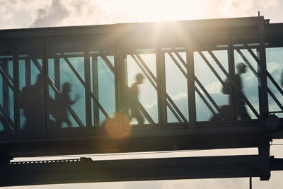 Silhouettes of people walking at busy airport. passengers walking inside boarding bridge.