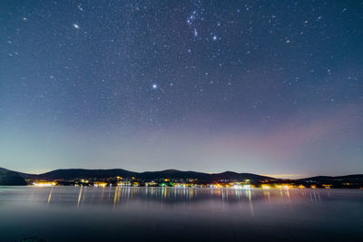 Scenic view of lake against sky at night