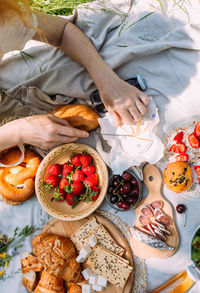 Picnic in the field with berries, juice, cheese, sausage and sweet croissants