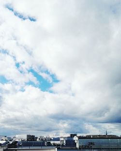 View of cityscape against cloudy sky