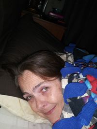 Portrait of smiling boy lying on bed at home