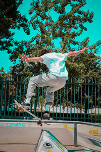 Man jumping in park against sky