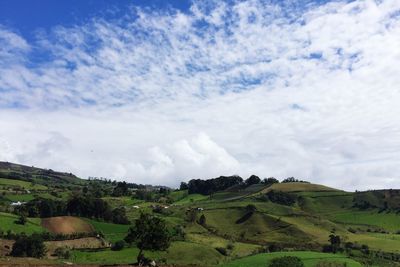 Scenic view of field against cloudy sky