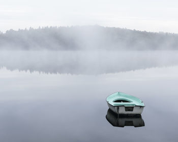 Rowboat on a smooth, misty lake