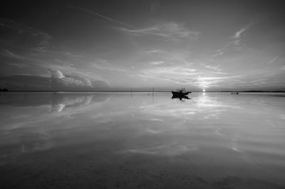 Silhouette person in lake against sky