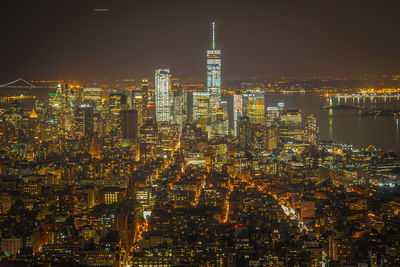 Illuminated cityscape against sky at night