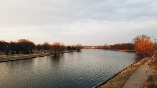 Scenic view of river against sky in city