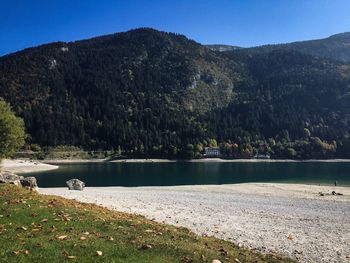 Scenic view of lake by mountains against clear sky