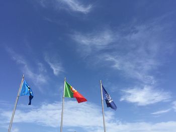 Low angle view of flags against blue sky