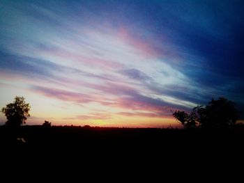 Silhouette landscape against sky at sunset