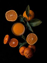 Top corner of orange fruits with juice and green leaves