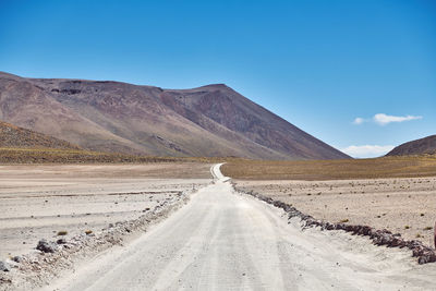 Scenic view of road amidst desert against sky