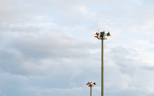 Low angle view of floodlights against sky