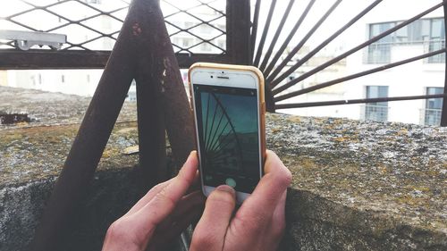 Close-up of hand photographing with mobile phone