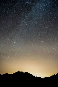 Scenic view of silhouette mountain against sky at night