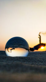 Close-up of wineglass against orange sky