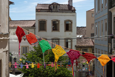 Multi colored flags hanging outside building against sky