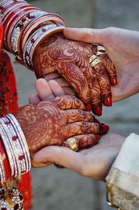 Cropped image of bridegroom holding bride hands