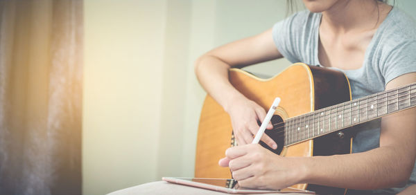 Close-up of woman holding guitar