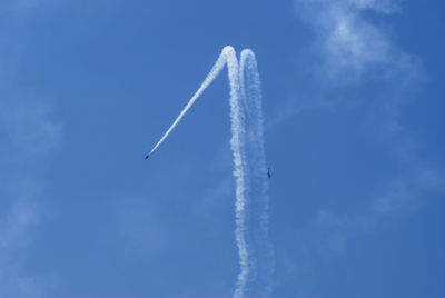 Low angle view of vapor trail against blue sky