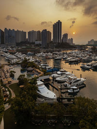 High angle view of marina and buildings against sky during sunset