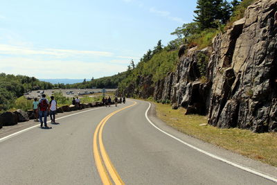 People riding motorcycle on road against sky