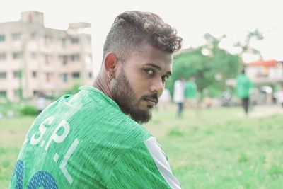 Portrait of young man sitting on field