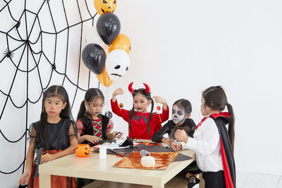 Rear view of people sitting on table