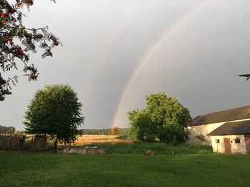 Scenic view of field against rainbow in sky