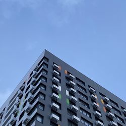 Low angle view of modern building against blue sky