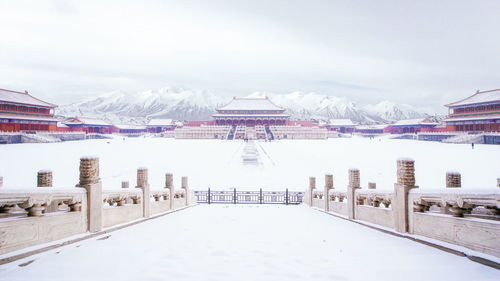 Built structure on snowcapped mountain against sky