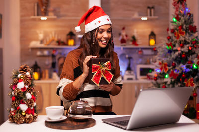 Young woman using mobile phone while sitting on table