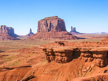 Man on cliff against clear sky