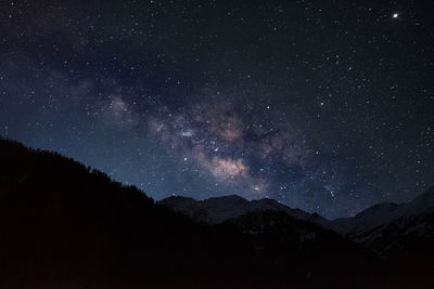 Scenic view of mountains against sky at night