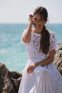 Happy young woman standing on beach