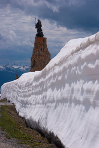 Scenic view of snow covered mountains against cloudy sky