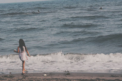 Rear view of woman standing on beach