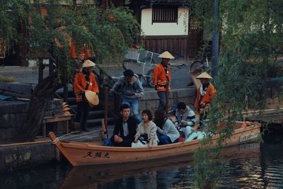 People on boats in canal along buildings