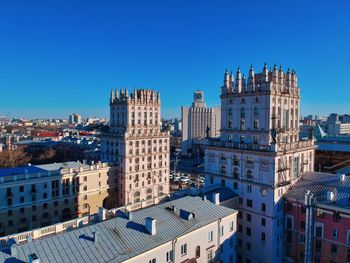 Buildings in city against blue sky