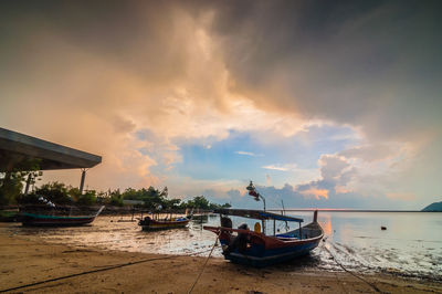 Boats in sea against cloudy sky