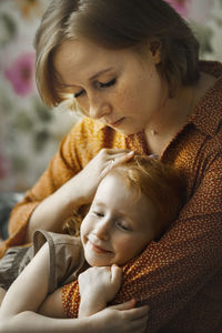 Young mother embracing daughter at home