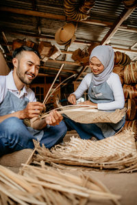 High angle view of siblings playing on hay